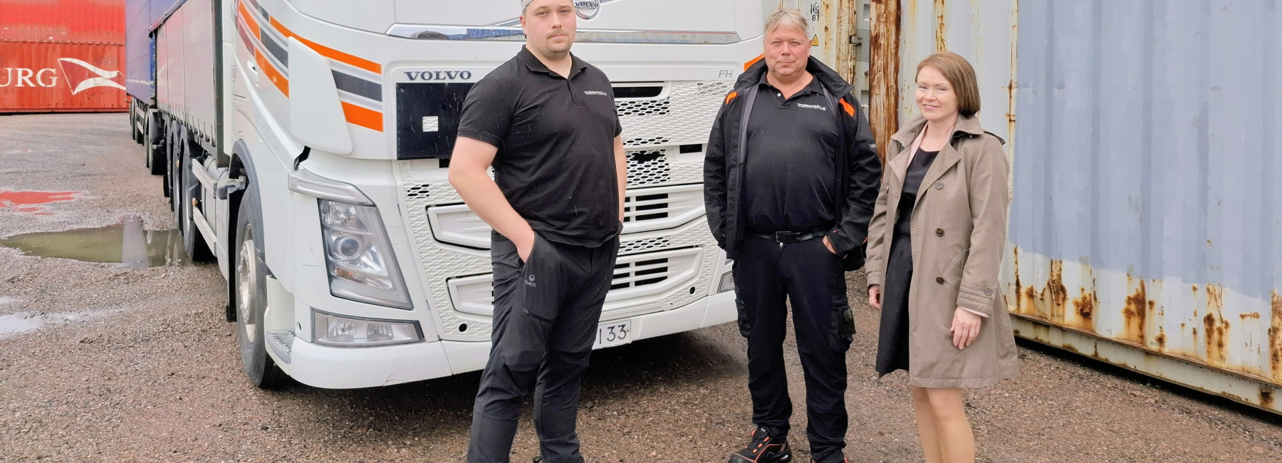Ylärakkola Logisticsin tärkeimmän työkalun eli auton edessä Mici-Matias ja Marco Ylärakkola sekä Pyhtään kunnanjohtaja Terhi Lindholm.