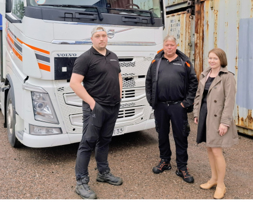 Ylärakkola Logisticsin tärkeimmän työkalun eli auton edessä Mici-Matias ja Marco Ylärakkola sekä Pyhtään kunnanjohtaja Terhi Lindholm.