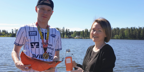 Kuvassa kunnanjohtaja ja Niki Lemberg veden äärellä, kädessään riippumatto ja vesipullo.