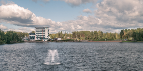 Kerrostalo järven rannalla, suihkulähde